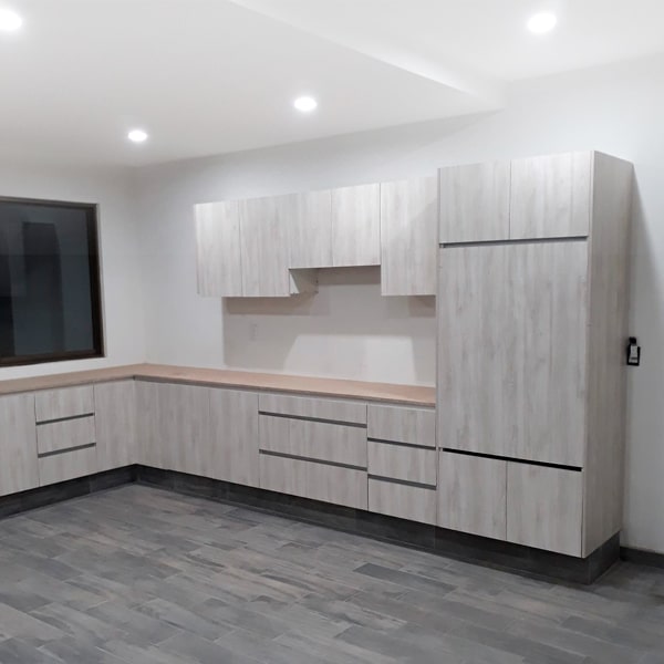 Cocina moderna con módulos inferiores y superiores de acabado fino, ejemplo de muebles finos en Ciudad de México